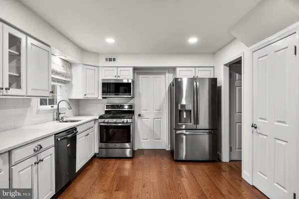 a kitchen with stainless steel appliances a refrigerator sink and microwave