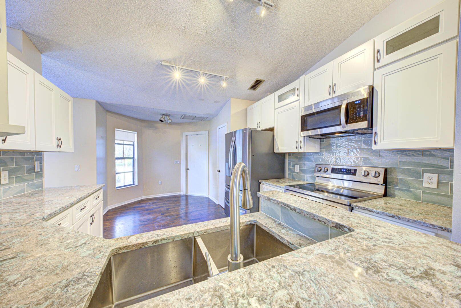 2423 Jaywood Road Titusville, FL 32780 - Photo 14 of 37 a kitchen with stainless steel appliances granite countertop a sink stove and refrigerator