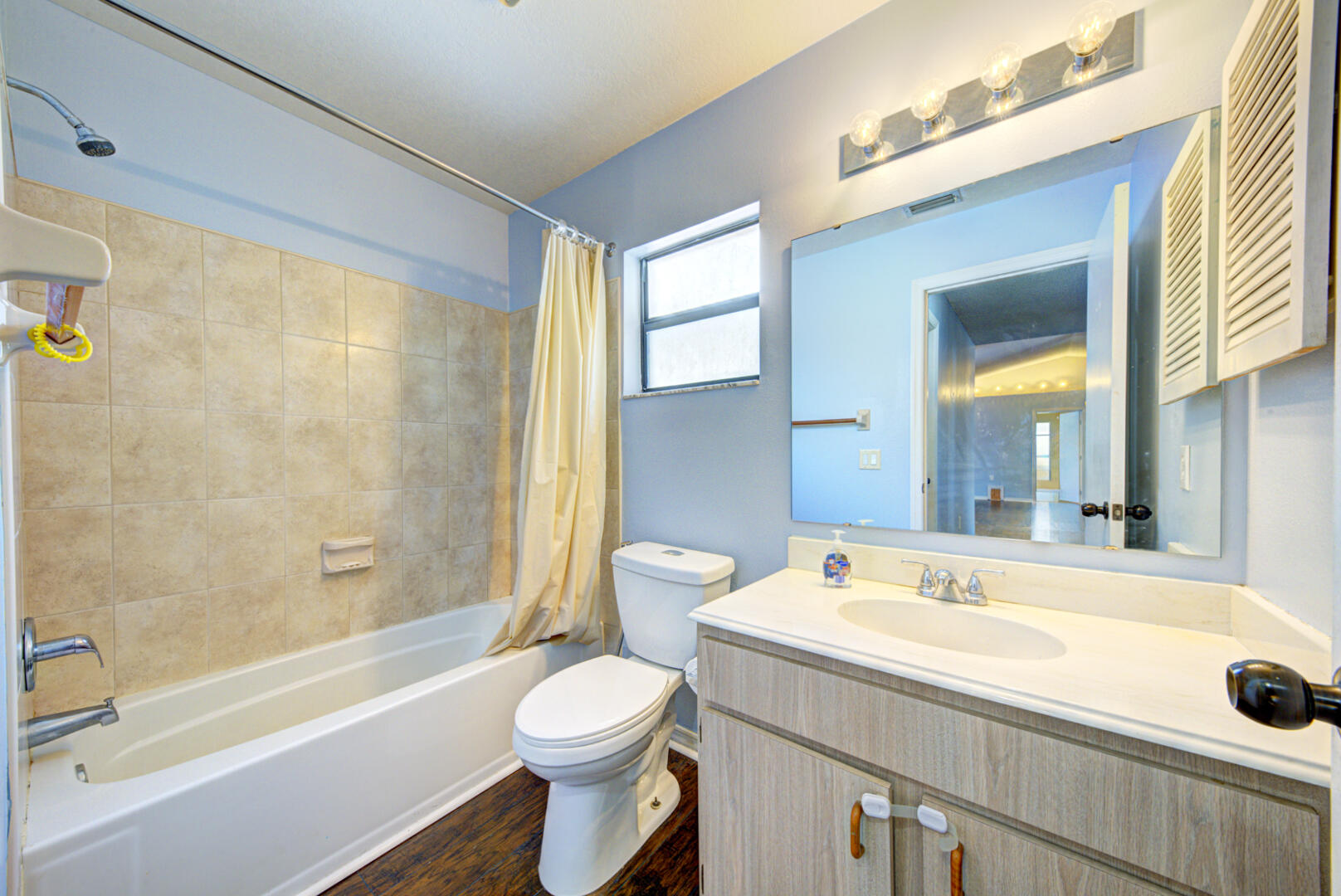2423 Jaywood Road Titusville, FL 32780 - Photo 19 of 37 a bathroom with a tub a sink and a large mirror next to a window