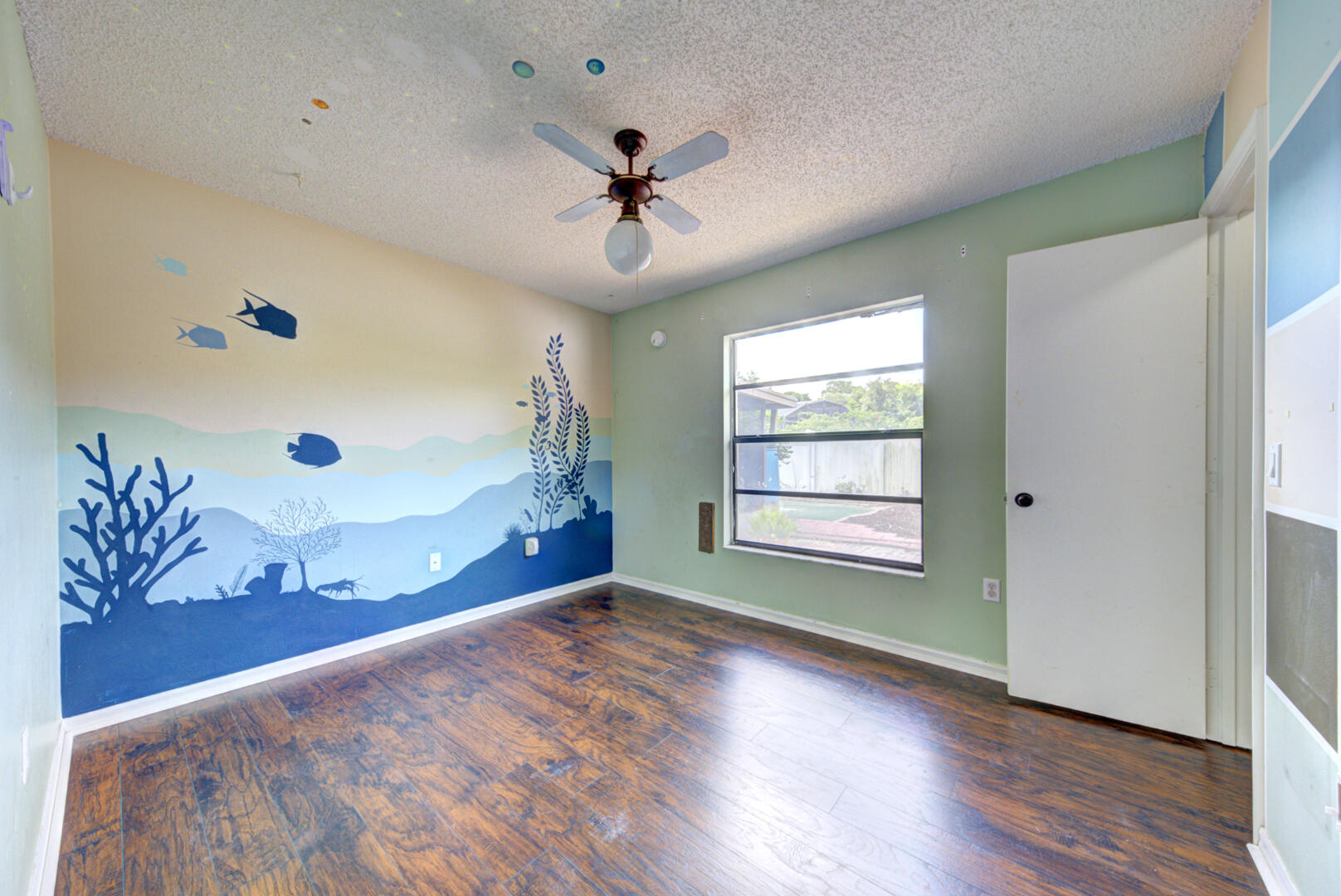 2423 Jaywood Road Titusville, FL 32780 - Photo 20 of 37 a view of an empty room with a window and wooden floor