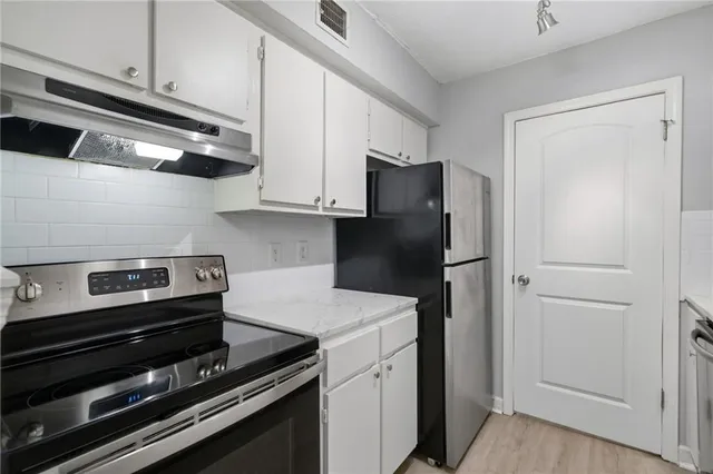 a kitchen with white cabinets and sink