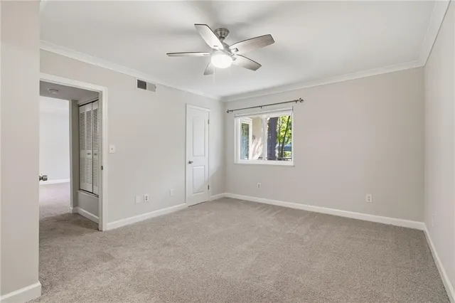 an empty room with a window and a fan