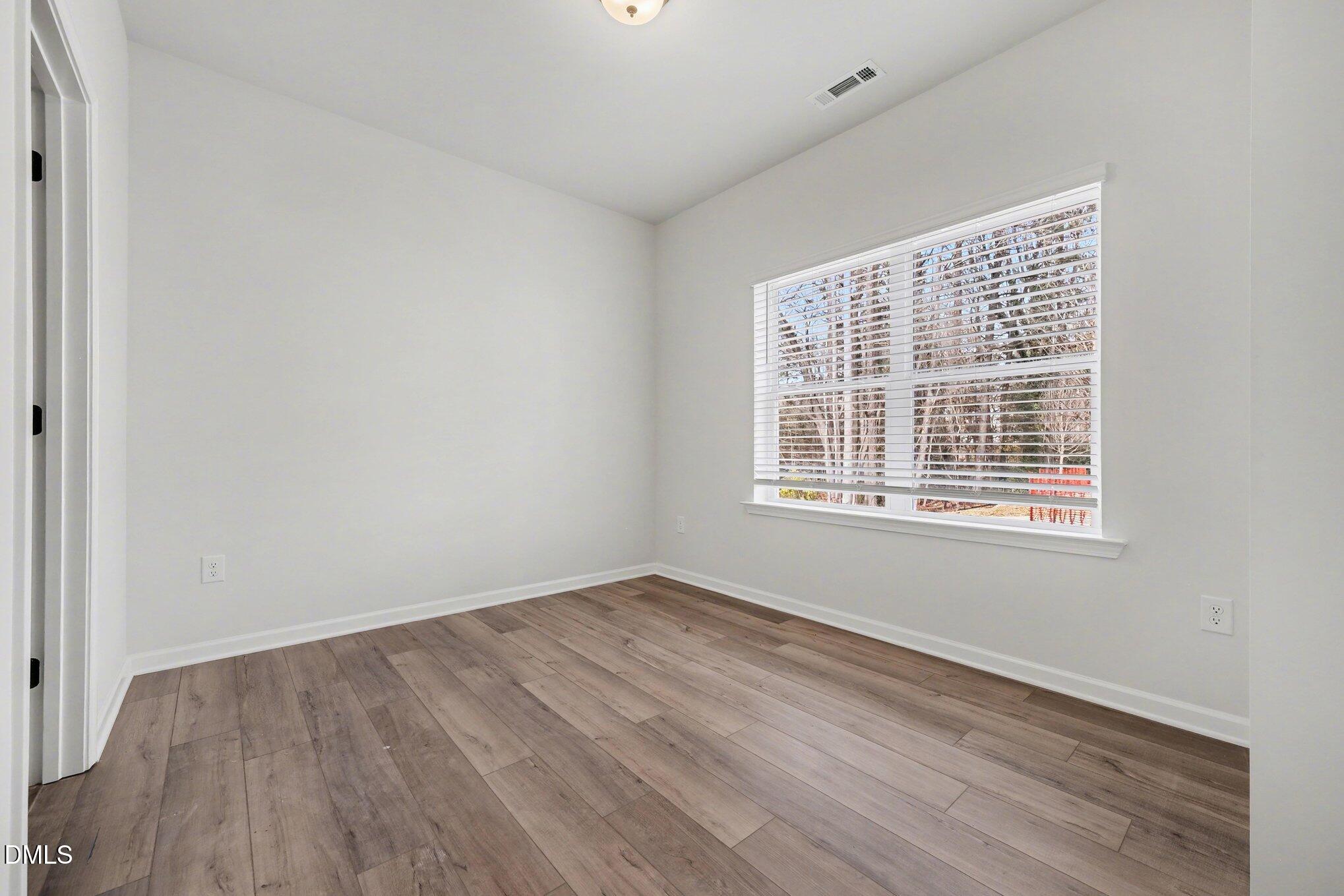 720 Orch Vista Circle Raleigh, NC 27606 - Photo 16 of 28 a view of an empty room with wooden floor and a window