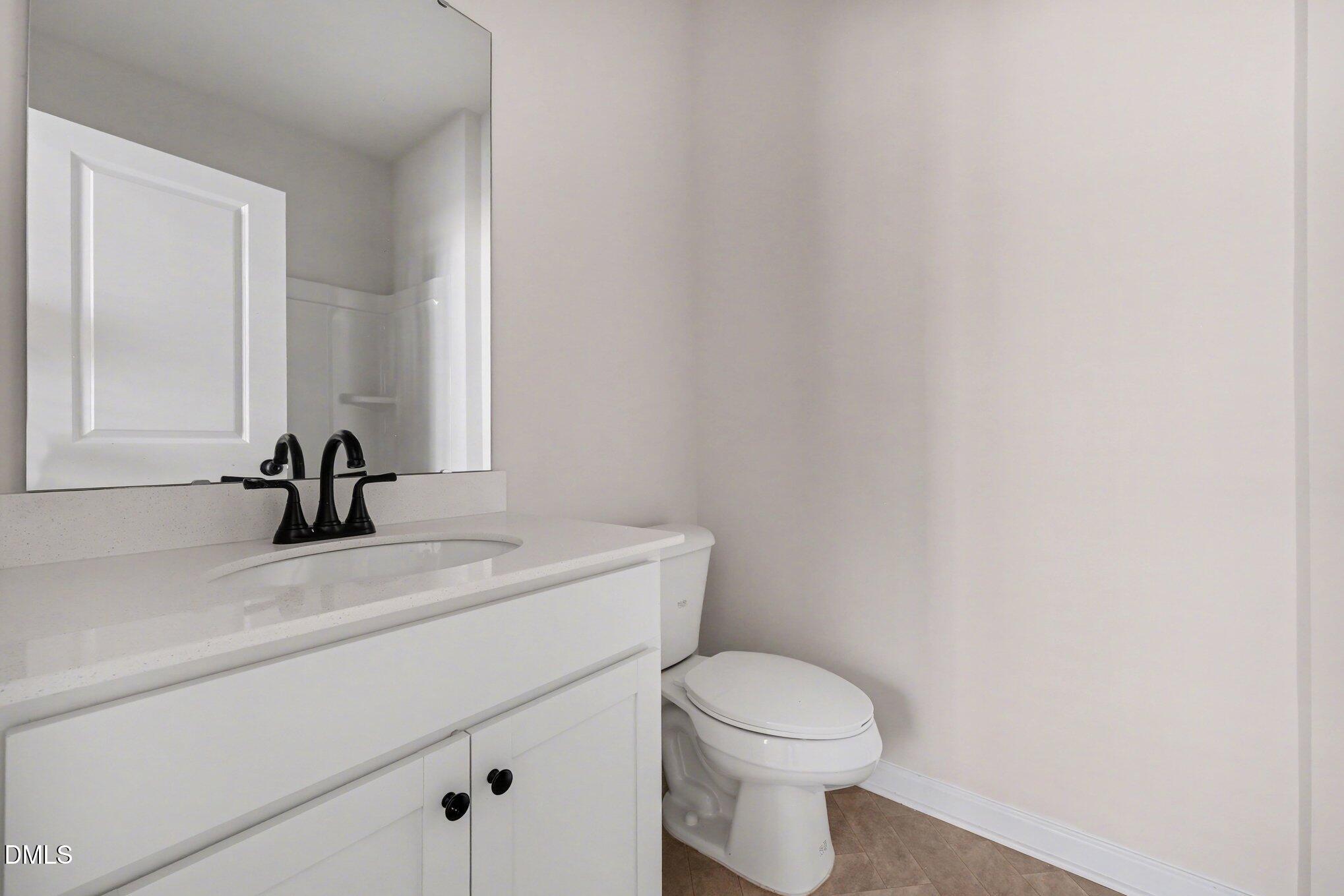 720 Orch Vista Circle Raleigh, NC 27606 - Photo 17 of 28 a bathroom with a sink a toilet and a mirror