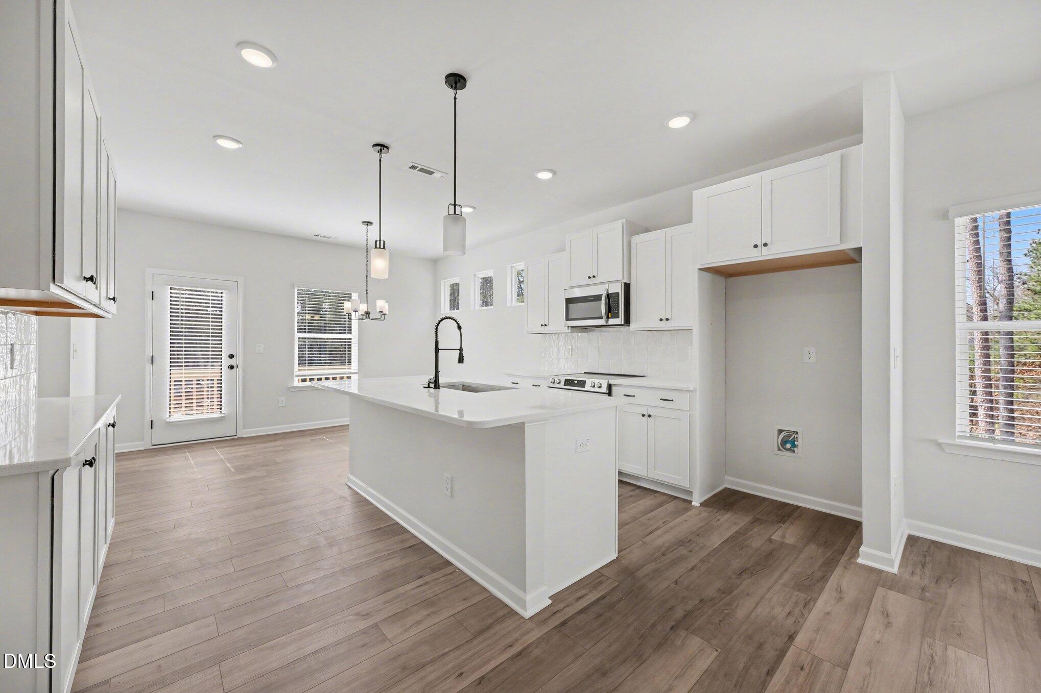 720 Orch Vista Circle Raleigh, NC 27606 - Photo 2 of 28 a large white kitchen with wooden floors and white walls