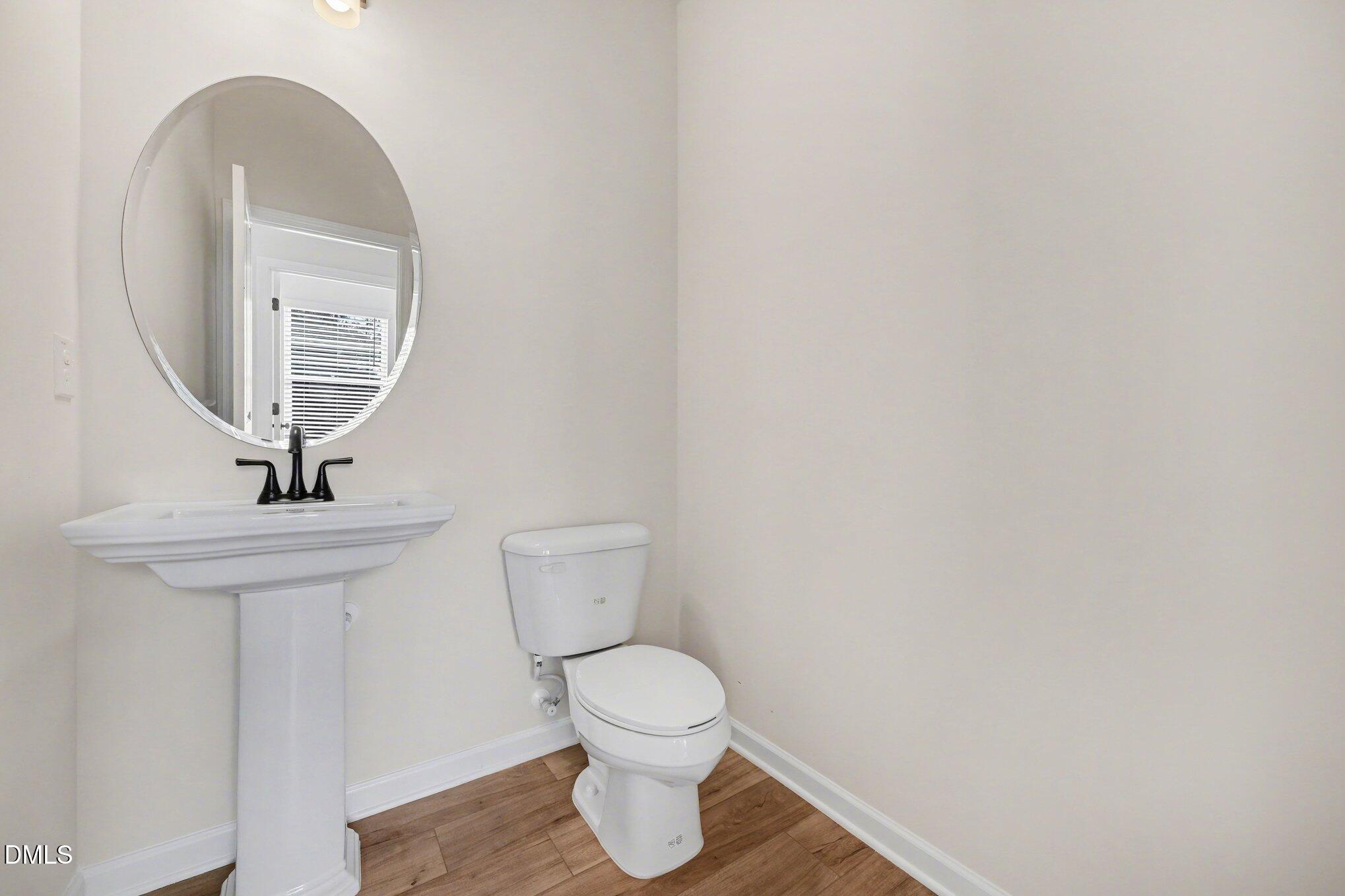 720 Orch Vista Circle Raleigh, NC 27606 - Photo 6 of 28 a bathroom with a toilet a sink and mirror