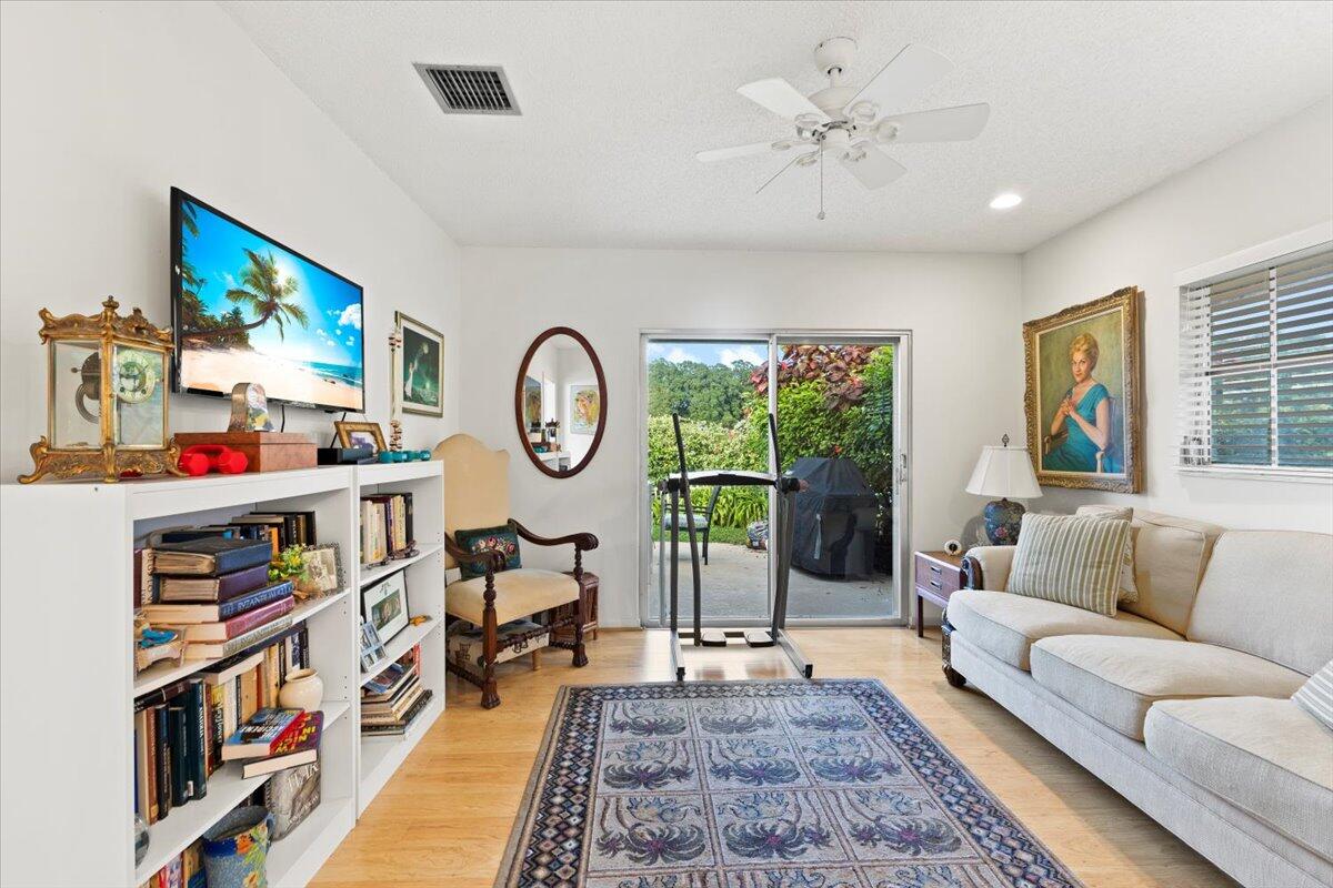 233 Rio Vista Circle, Unit 233 Atlantis, FL 33462 - Photo 20 of 33 a living room with lots of furniture and a book shelf