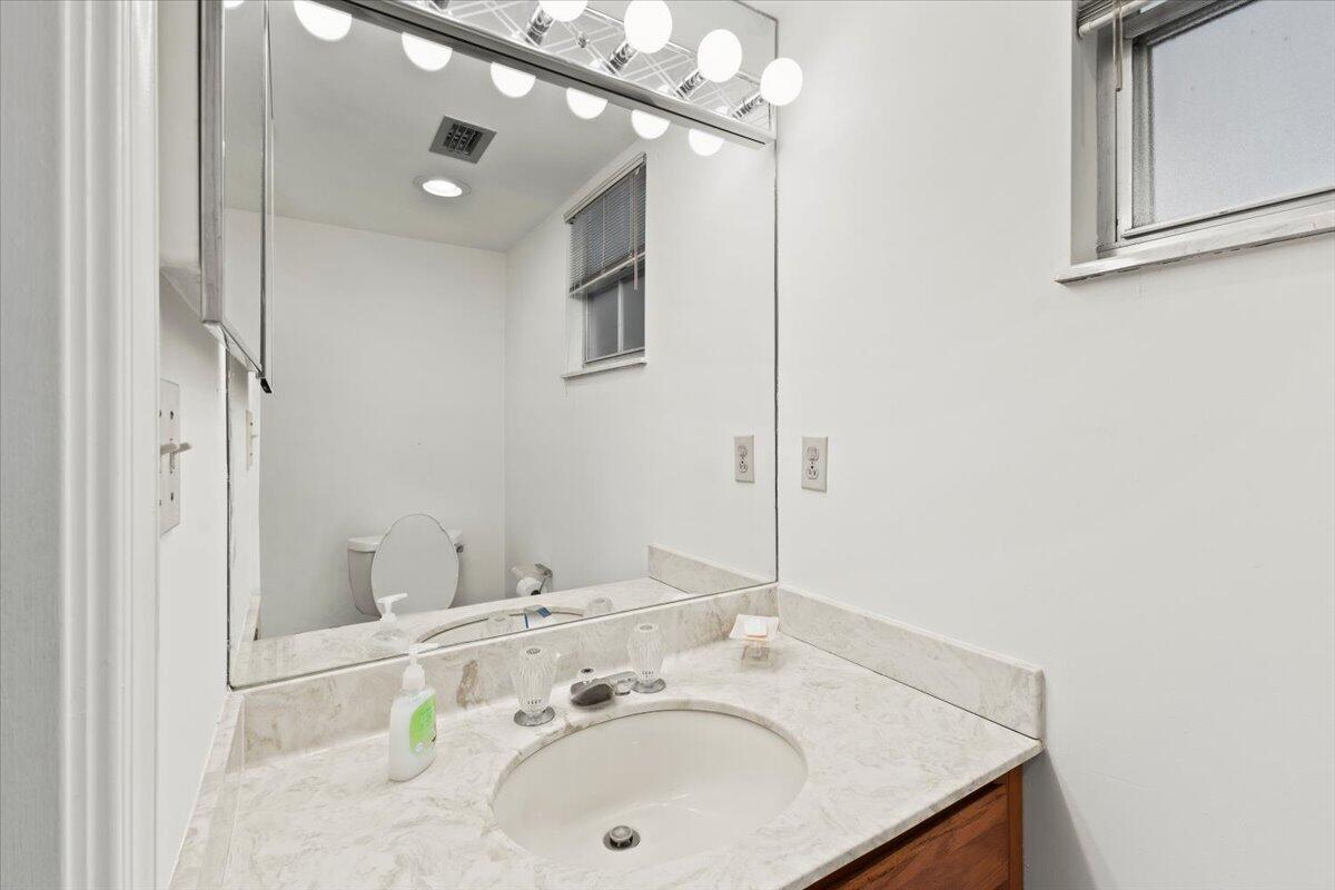 233 Rio Vista Circle, Unit 233 Atlantis, FL 33462 - Photo 21 of 33 a bathroom with a sink and a mirror