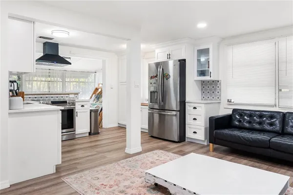 a kitchen with stainless steel appliances kitchen island granite countertop a refrigerator and a stove top oven