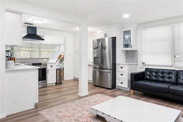 a kitchen with stainless steel appliances kitchen island granite countertop a refrigerator and a stove top oven