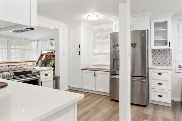 a kitchen with a refrigerator and a stove top oven