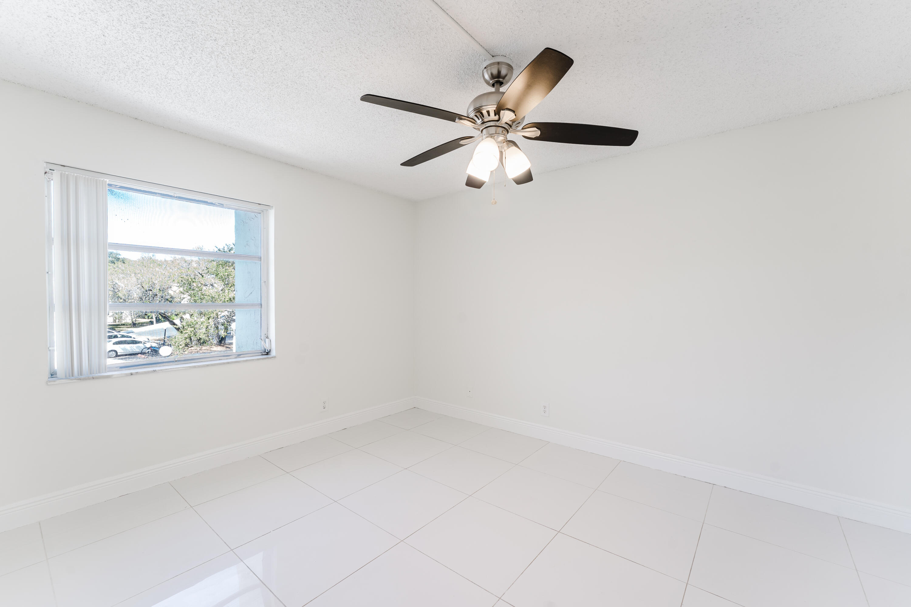 606 Northwest 13th Street, Unit 23 Boca Raton, FL 33486 - Photo 19 of 37 an empty room with a window and a fan