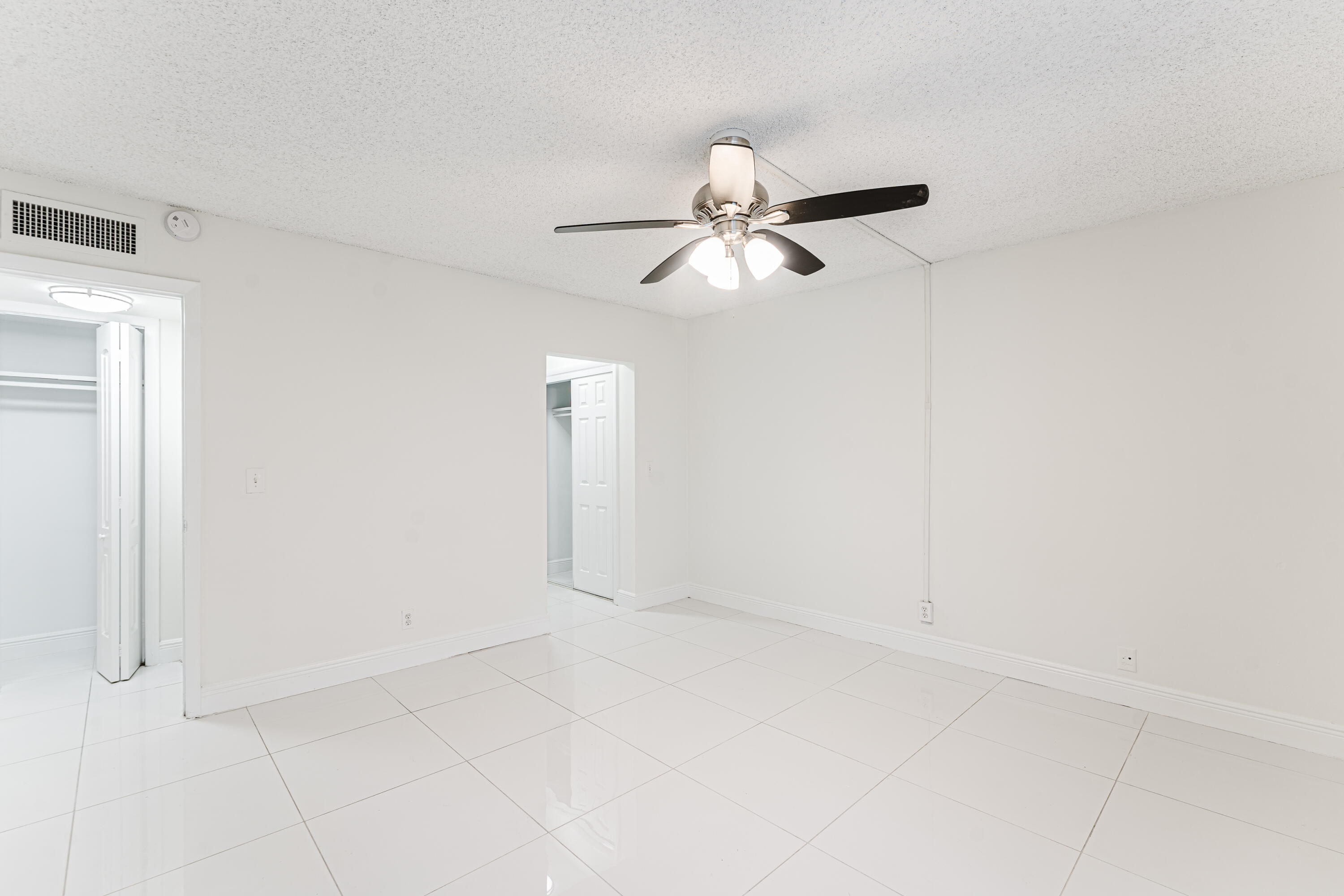 606 Northwest 13th Street, Unit 23 Boca Raton, FL 33486 - Photo 23 of 37 an empty room with a empty space and a ceiling fan