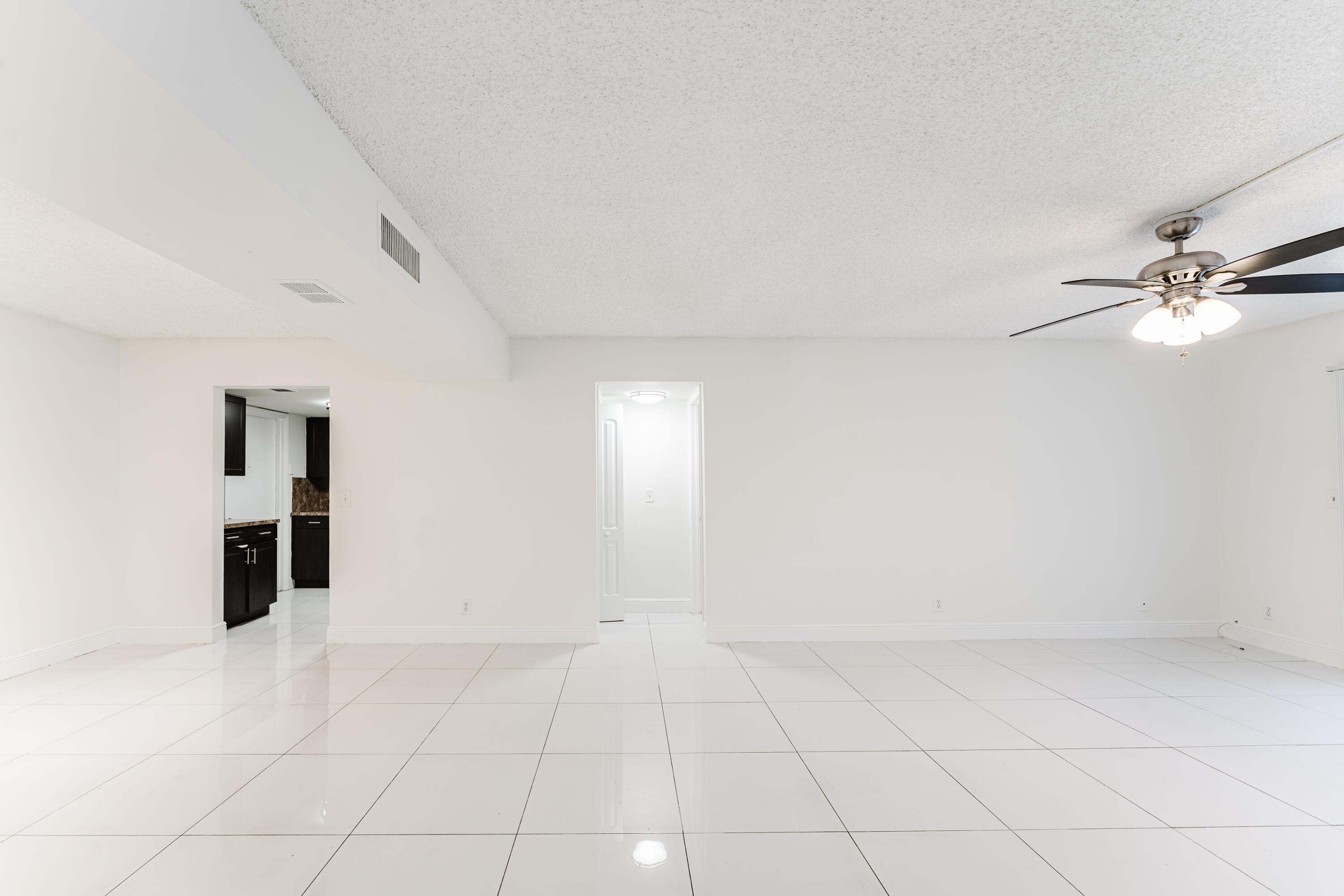 606 Northwest 13th Street, Unit 23 Boca Raton, FL 33486 - Photo 7 of 37 an empty room with windows and ceiling fan