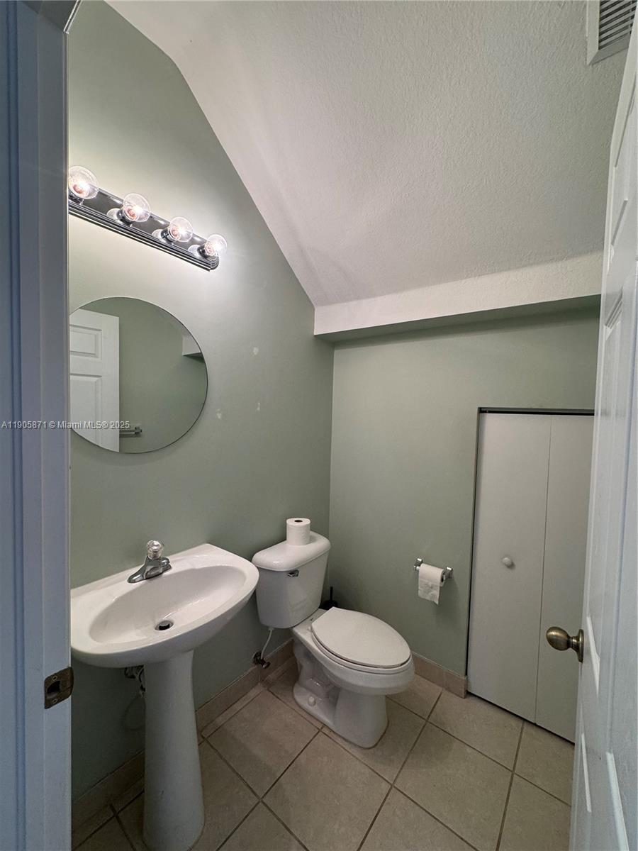 3166 Merrick Terrace, Unit 1705 Margate, FL 33063 - Photo 12 of 41 a bathroom with a toilet sink and mirror