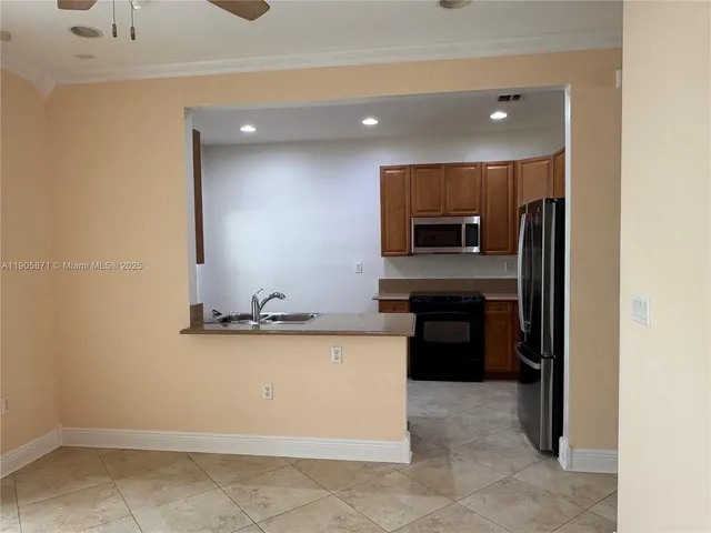a kitchen with granite countertop a refrigerator and a sink