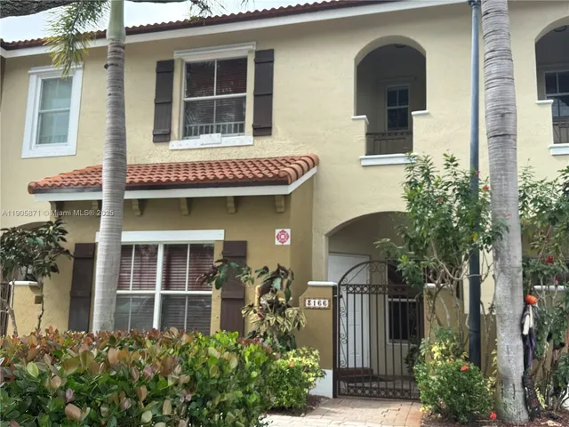 a front view of a house with plants