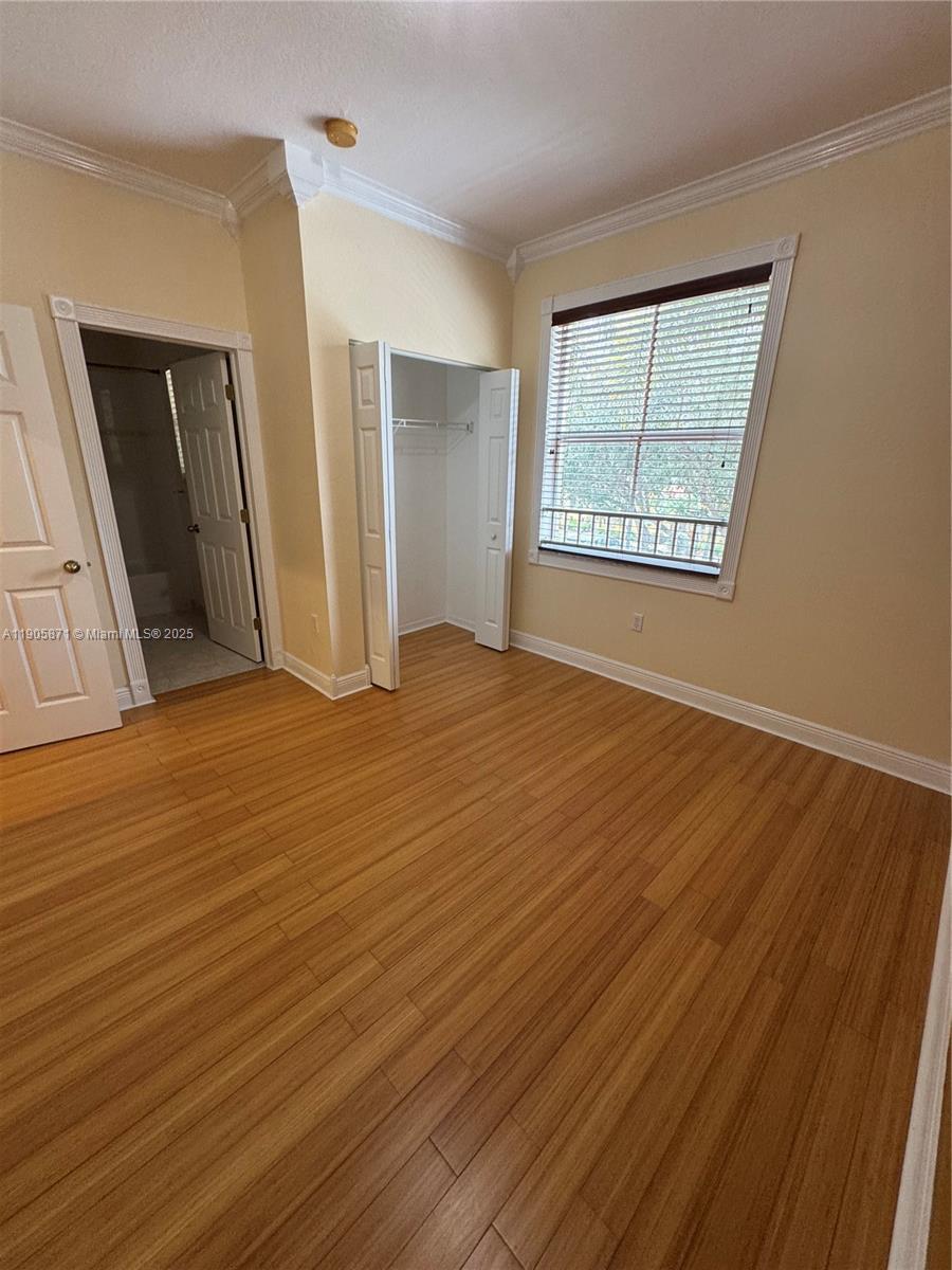 3166 Merrick Terrace, Unit 1705 Margate, FL 33063 - Photo 37 of 41 a view of an empty room with wooden floor and a window