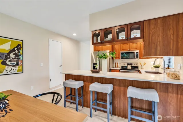 a kitchen with a table chairs a sink dishwasher window and cabinets