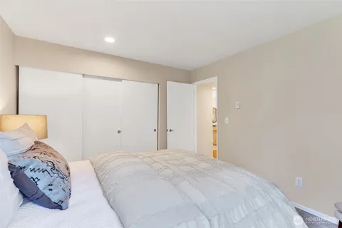 a bedroom with a large bed and a lamp