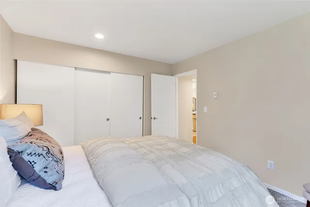 a bedroom with a large bed and a lamp