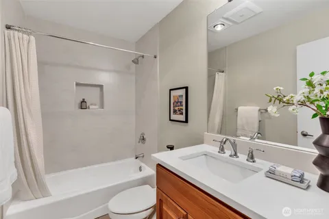 a bathroom with a granite countertop sink toilet and shower