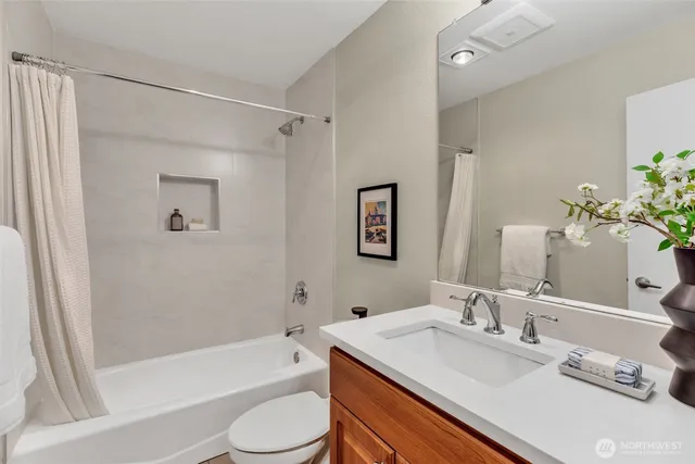 a bathroom with a granite countertop sink toilet and shower
