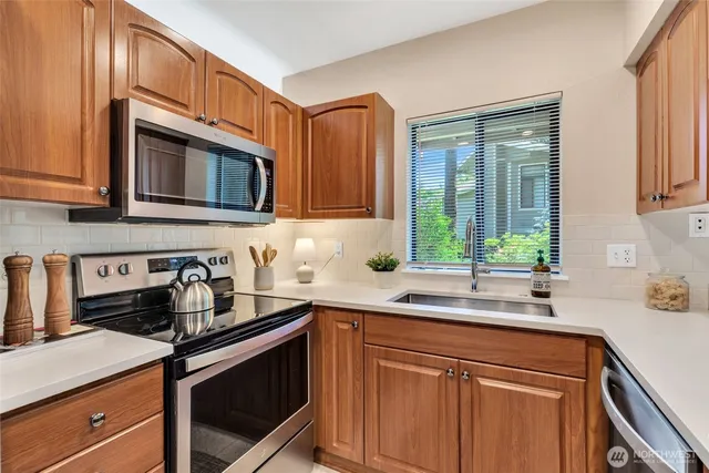 a kitchen with stainless steel appliances granite countertop a sink stove and microwave