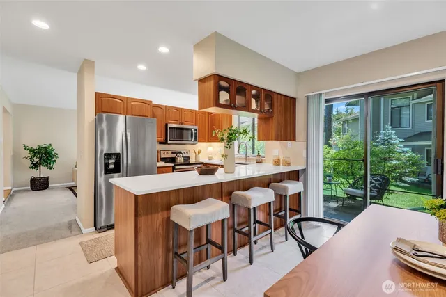 a living room with furniture a large window and kitchen view
