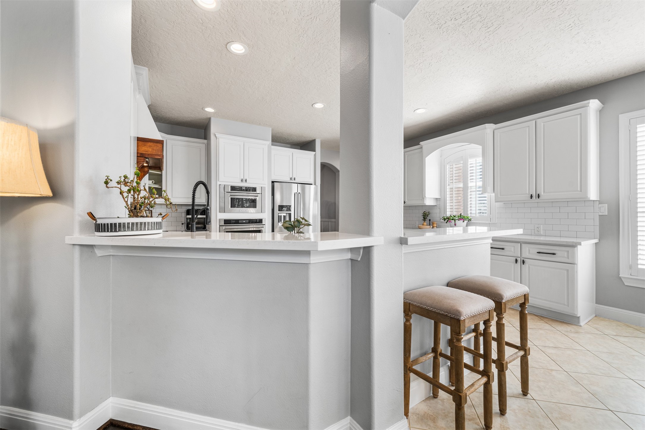 28446 Shining Creek Lane Spring, TX 77386 - Photo 19 of 47 a kitchen with kitchen island granite countertop wooden cabinets and white appliances