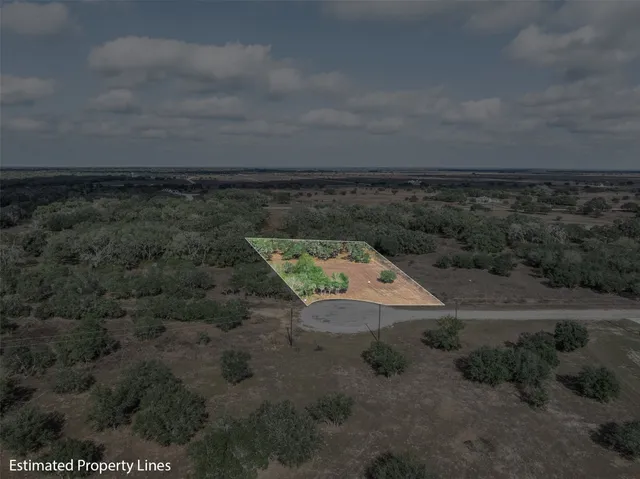 a view of a dry yard with wooden fence