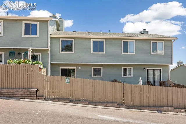 a view of a house with a wooden fence