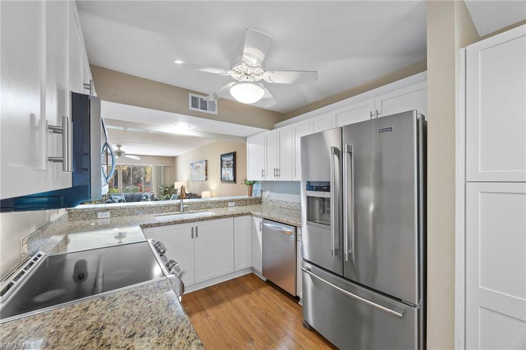 a kitchen with stainless steel appliances granite countertop a refrigerator and a sink