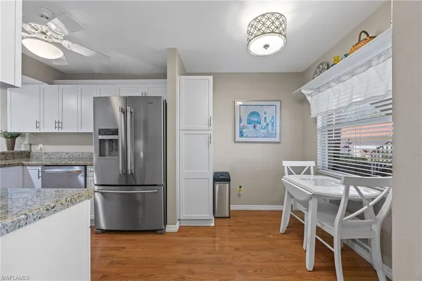 a kitchen with stainless steel appliances granite countertop a refrigerator and a stove top oven