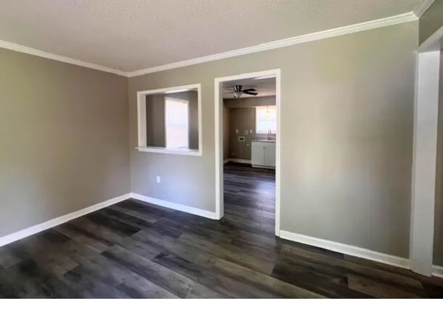 a room with wooden floor and windows