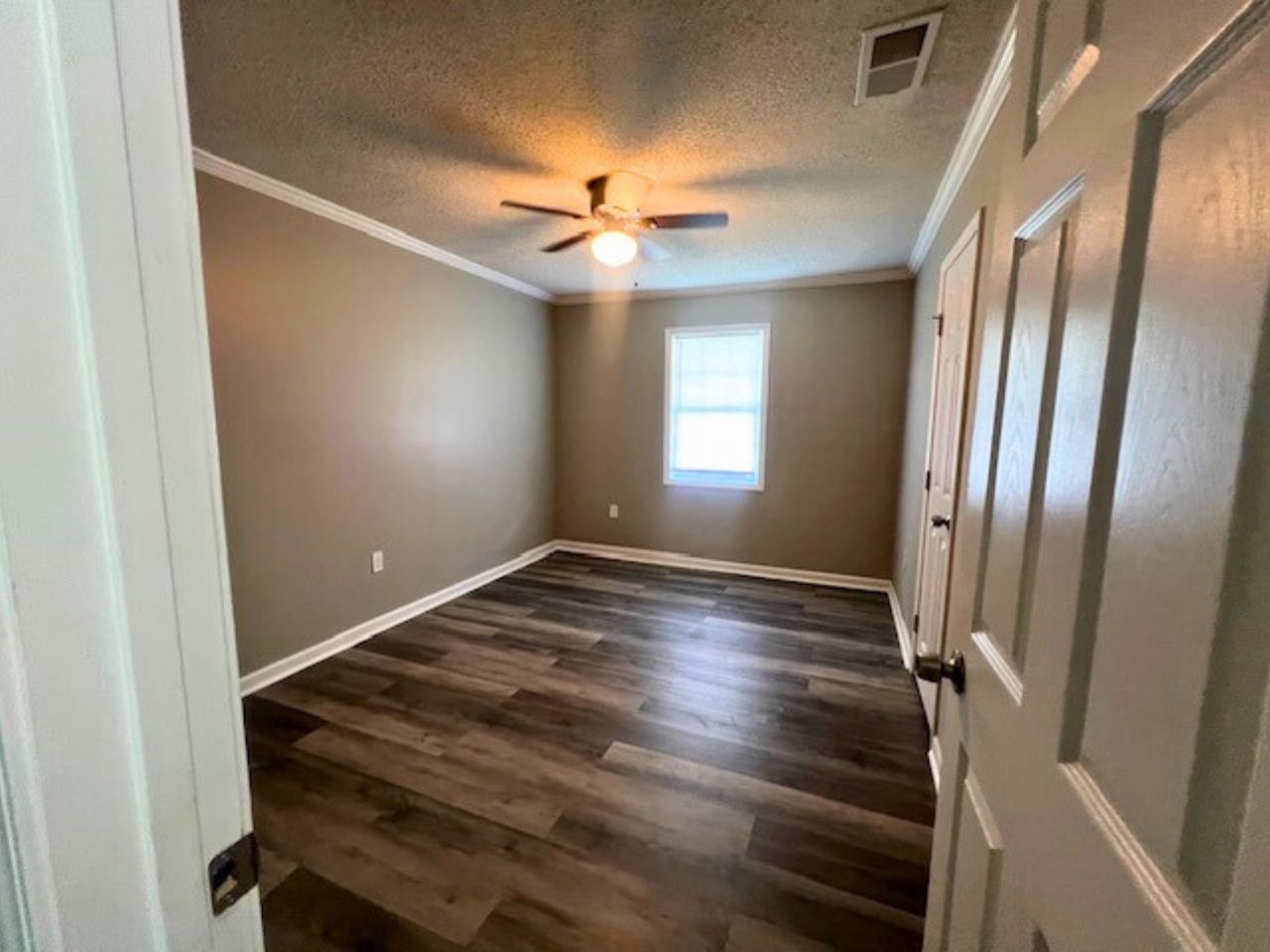 4710 Hillbrook Road Memphis, TN 38109 - Photo 6 of 11 a view of an empty room with window and wooden floor