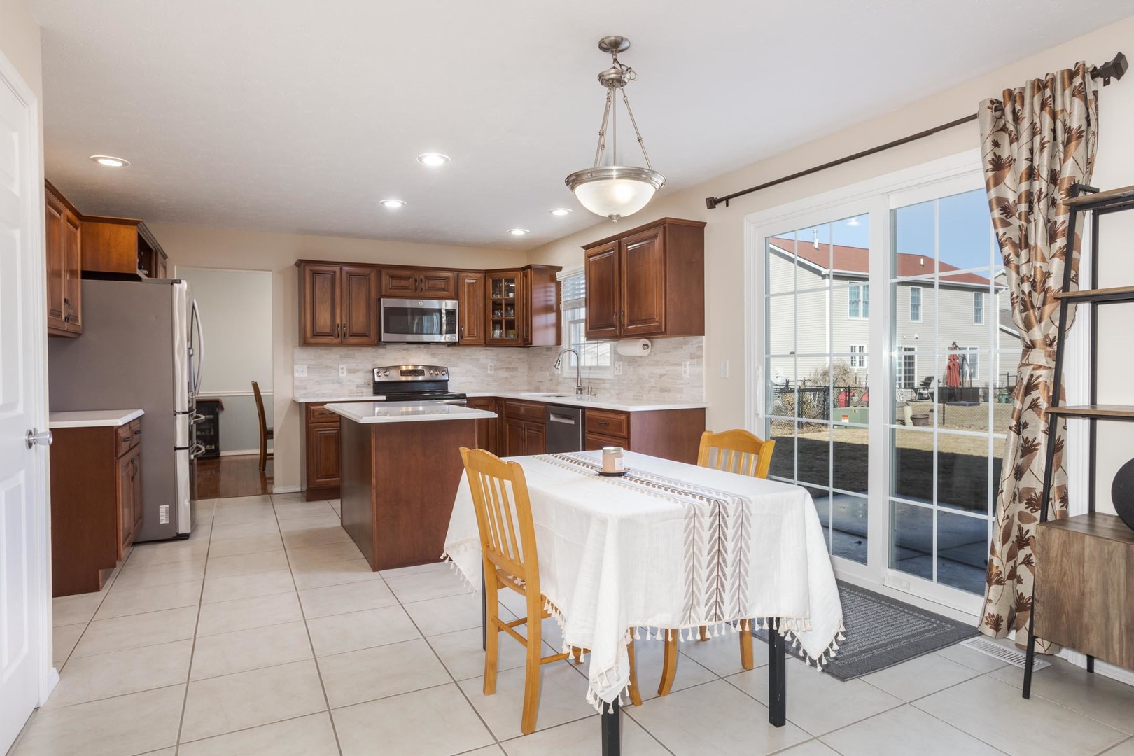 2884 Three Eagles Street Normal, IL 61761 - Photo 18 of 48 a kitchen with stainless steel appliances granite countertop a stove top oven a sink a dining table and chairs
