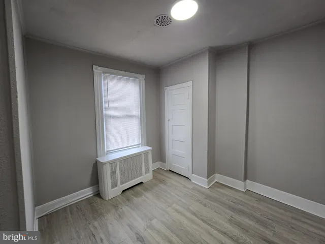 an empty room with wooden floor and closet