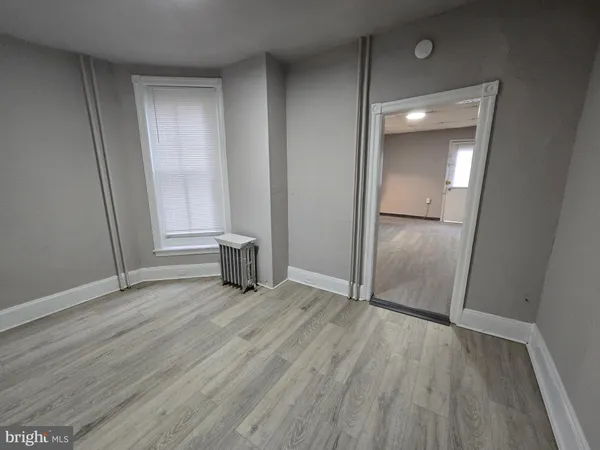 an empty room with wooden floor and closet