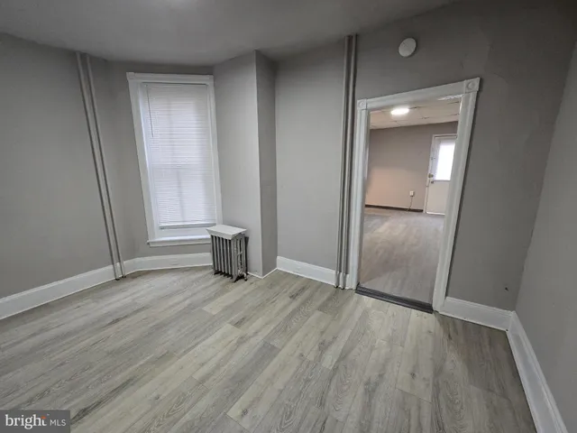 an empty room with wooden floor and closet