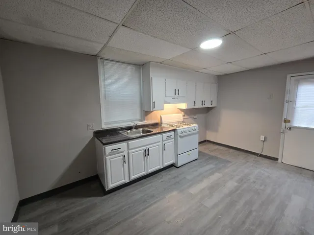 a kitchen with granite countertop white cabinets and white appliances