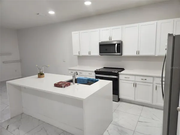 a kitchen with white cabinets sink and stainless steel appliances