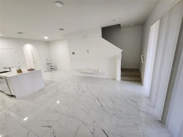a view of a big room with kitchen and natural light