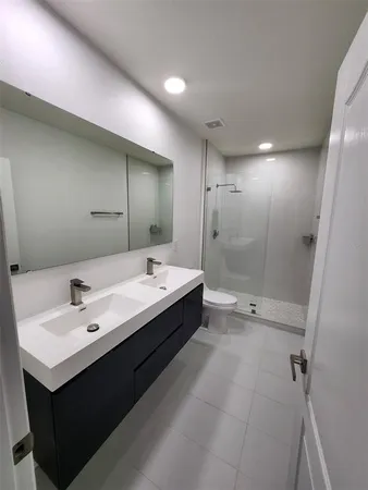 a bathroom with a double vanity sink mirror and shower