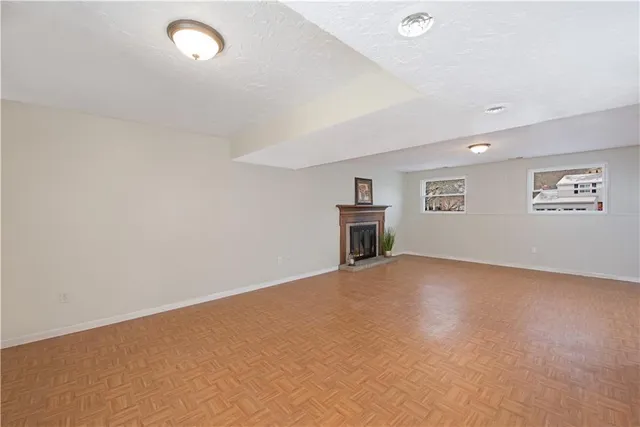 a view of an empty room with a kitchen and a refrigerator