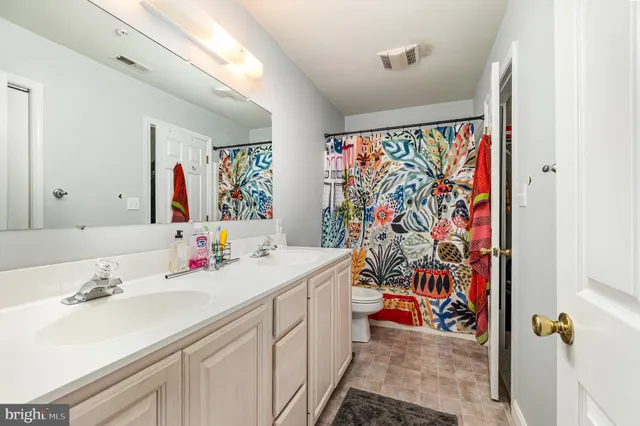 a bathroom with double vanity sink a mirror and shower