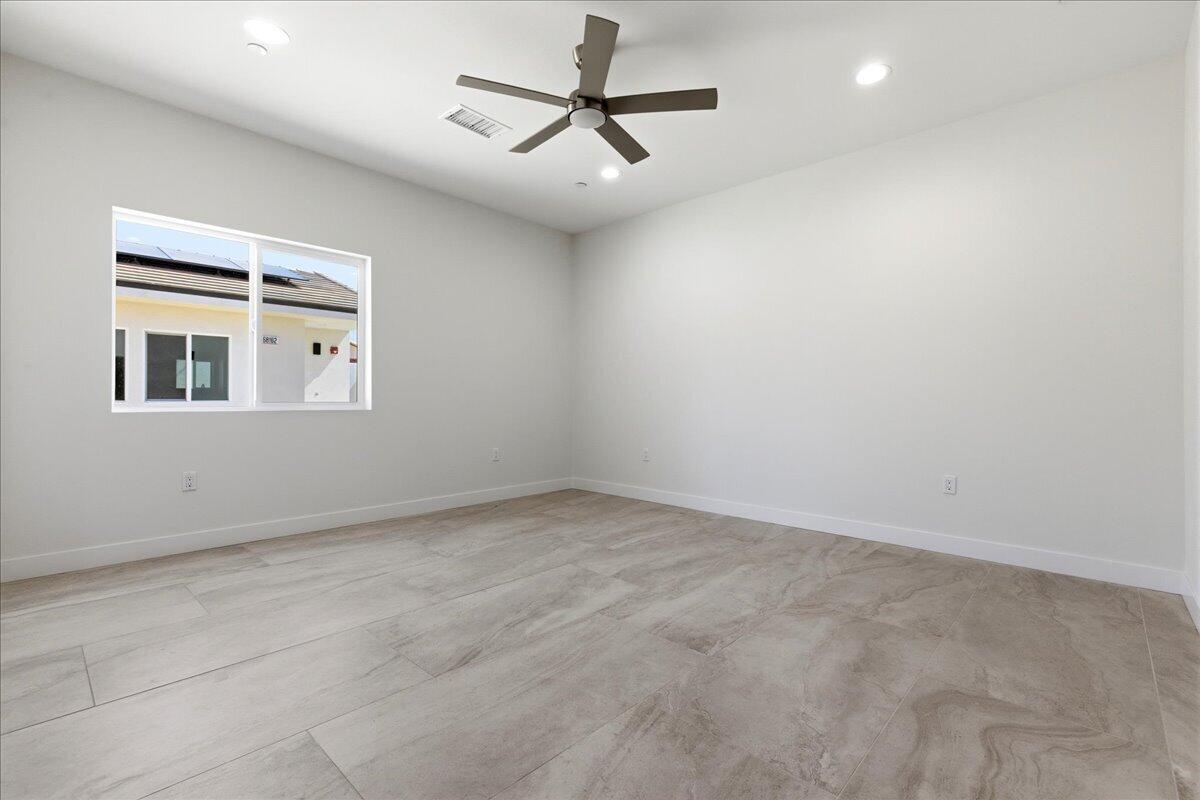 68160 Modalo Road Cathedral City, CA 92234 - Photo 15 of 57 an empty room with a chandelier fan and windows