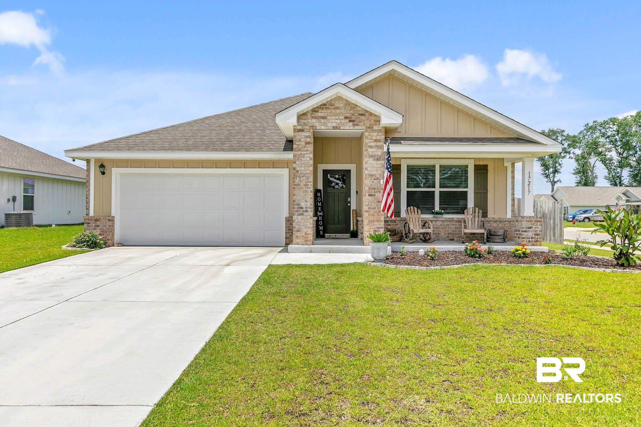 17217 REFLECTION Street Loxley, AL 36551 - Photo 1 of 83 View of front of home with brick siding, board and batten siding, a garage, a front lawn, and concrete driveway