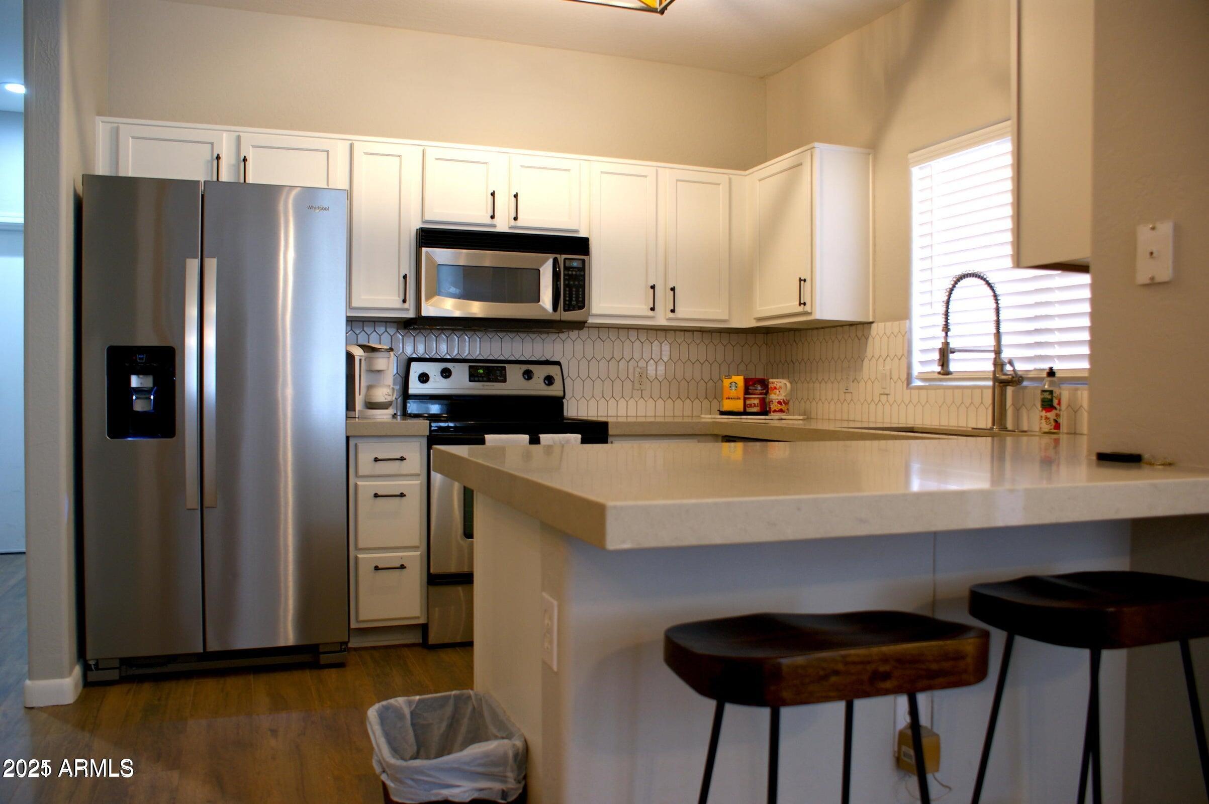 525 North Miller Road, Unit 145 Scottsdale, AZ 85257 - Photo 6 of 9 a kitchen with stainless steel appliances a refrigerator a sink a stove and cabinets