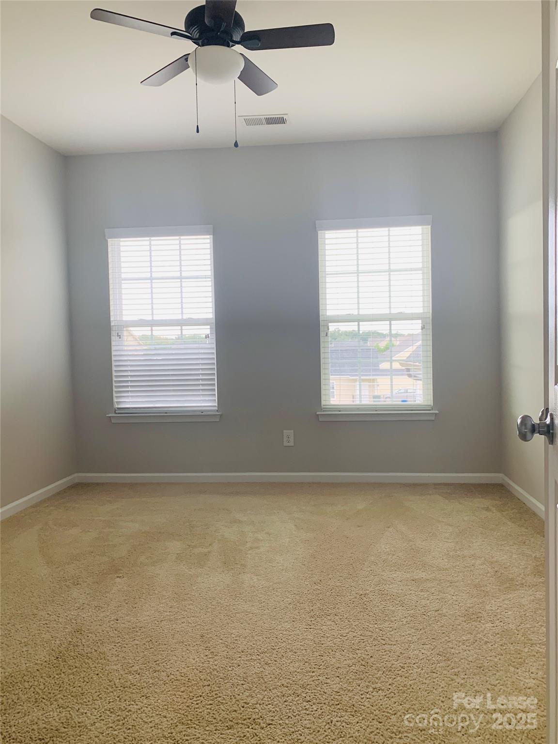 1472 Chandler Avenue Northwest Concord, NC 28027 - Photo 17 of 21 an empty room with a chandelier fan and windows